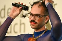 The author took to the stage and sang a song, before using an electric razor to shave off their hair on the podium