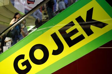 Commuters pass by a Gojek advertisement in Singapore