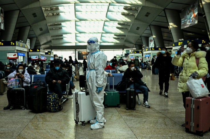 A passenger wearing protective gear is seen at a train station in Beijing on December 28