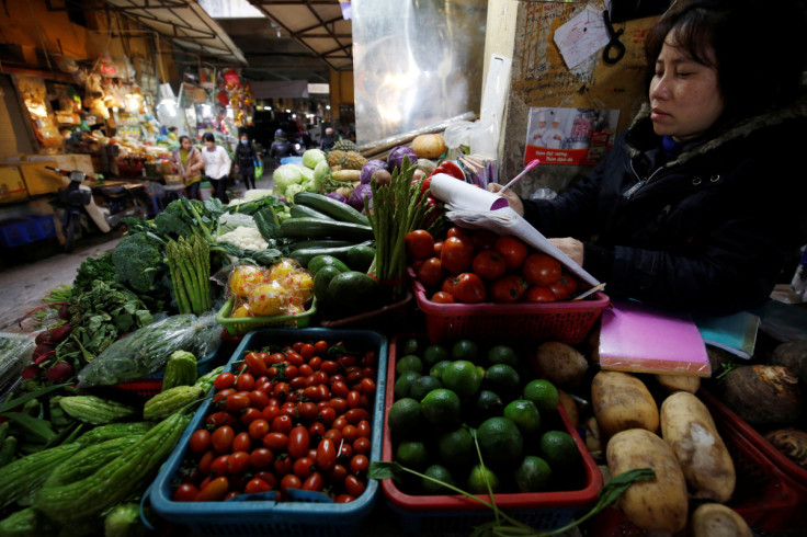 A woman sells vegetables at a market in Hanoi