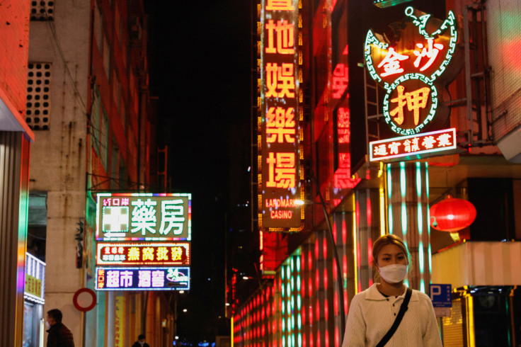A woman wearing face mask walks under neon lights near a casino during the coronavirus disease (COVID-19) pandemic in Macau