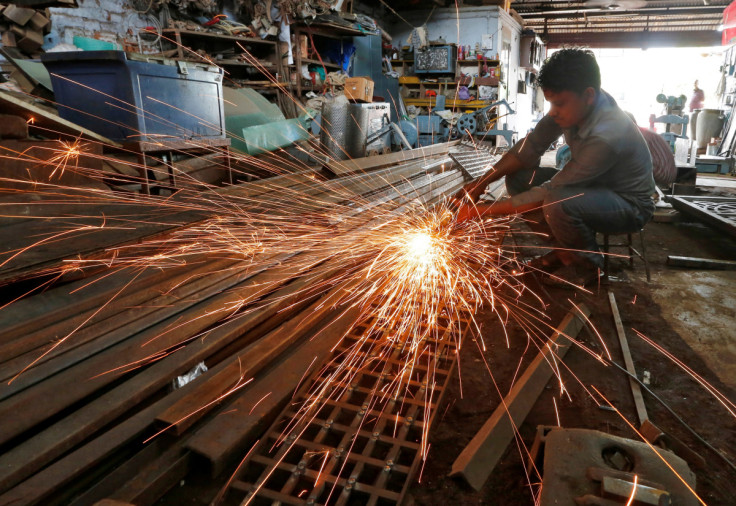A worker grinds a metal gate inside a household furniture manufacturing factory in Ahmedabad