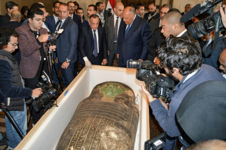 Egypt's Foreign Minister Sameh Shoukry (C-R) and the head of the Supreme Council of Antiquities Mostafa Waziri (C-L) inspect the "Green Sarcophagus"