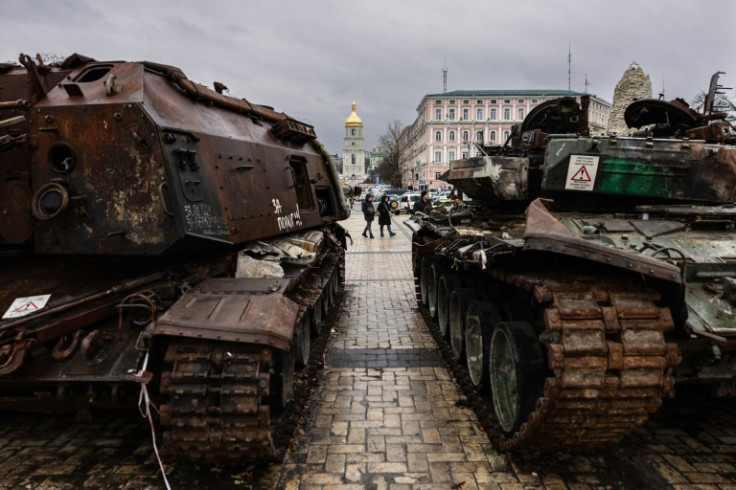 Pedestrians look at destroyed Russian military vehicles at an open air exhibition in Kyiv