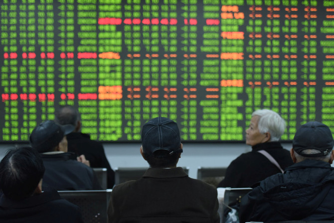 Investors sit in front of a board showing stock information at a brokerage house on the first day of trade in China since the Lunar New Year, in Hangzhou