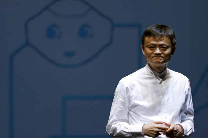 Jack Ma, founder and executive chairman of China's Alibaba Group, speaks in front of a picture of SoftBank's human-like robot named 'pepper' during a news conference in Chiba