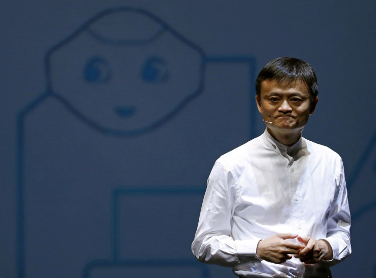 Jack Ma, founder and executive chairman of China's Alibaba Group, speaks in front of a picture of SoftBank's human-like robot named 'pepper' during a news conference in Chiba