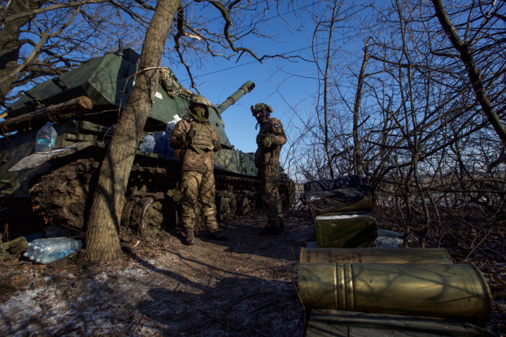 Ukrainian servicemen stand next to a 2S3 Akatsiya self propelled howitzer at their position in a frontline in Donetsk region
