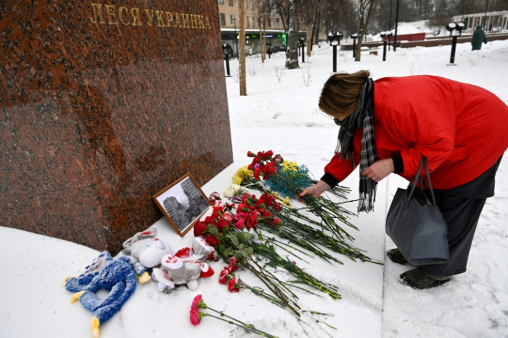 A woman lays flowers in memory of those killed in the weekend strike on a residential block in the Ukrainian city of Dnipro