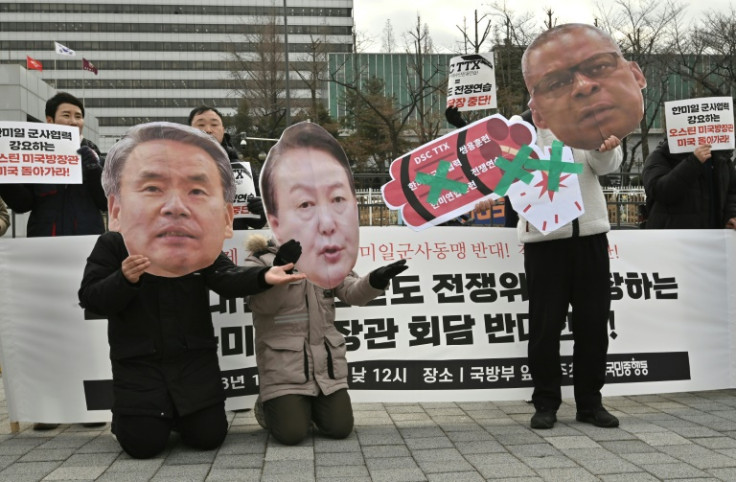 Anti-war activists in Seoul hold images of South Korean President Yoon Suk-yeol (C), Defense Minister Lee Jong-sup (L) and US Secretary of Defense Lloyd Austin