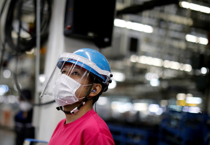 An employee wearing a protective face mask and face guard works on the automobile assembly line during the outbreak of the coronavirus disease (COVID-19) at the factory of Mitsubishi Fuso Truck and Bus Corp. in Kawasaki