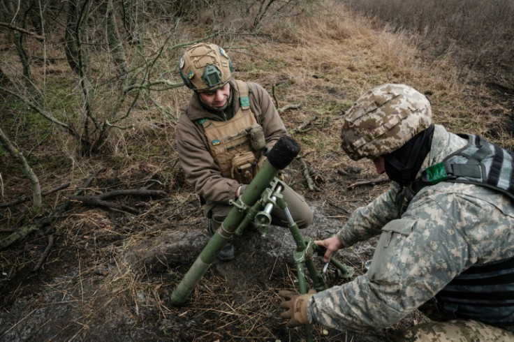 Ukrainian servicemen adjust a 60mm mortar tube near the frontline in the Donetsk region