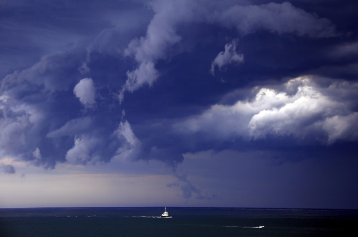 Boats head into shore as storm clouds move along the coast towards the city of Sydney, Australia
