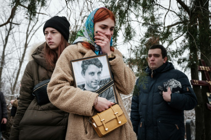 Kateryna Avdeyeva holds a portrait of her late friend, Ukrainian serviceman, 28-year-old orphan Oleksandr Korovniy, killed in Bakhmut
