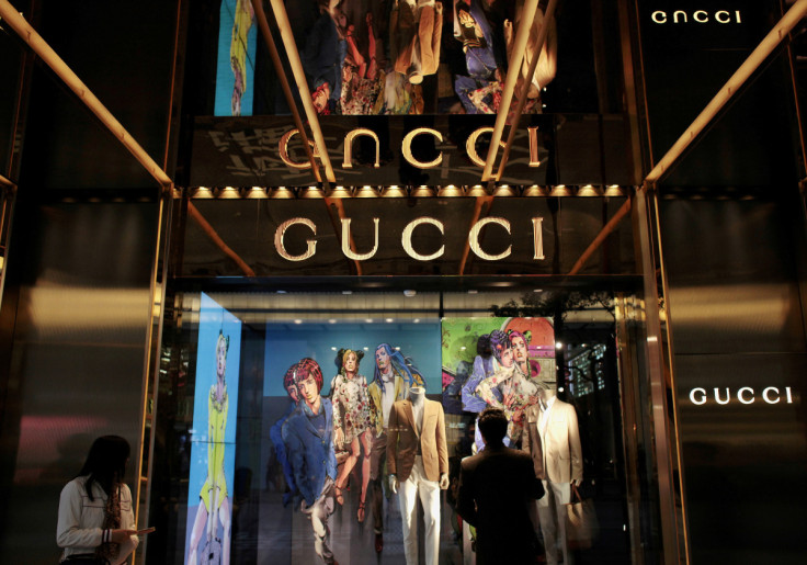 Man watches in front of window display outside a Gucci store in Hong Kong