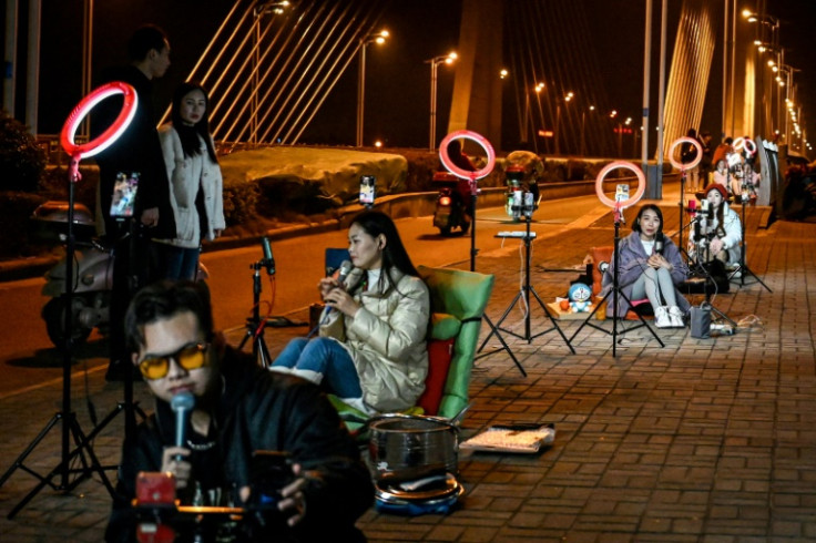 Outdoor livestreamers sing and chat with their online audiences on a bridge in Guilin