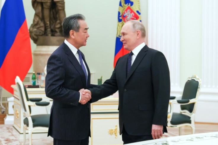 Russian President Vladimir Putin (R) met with China's top diplomat Wang Yi on Wednesday