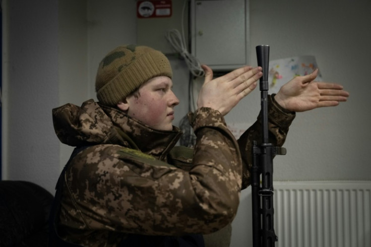 A member of a Ukrainian volunteer unit and a computer science student, checks his unit's Soviet-era machine gun