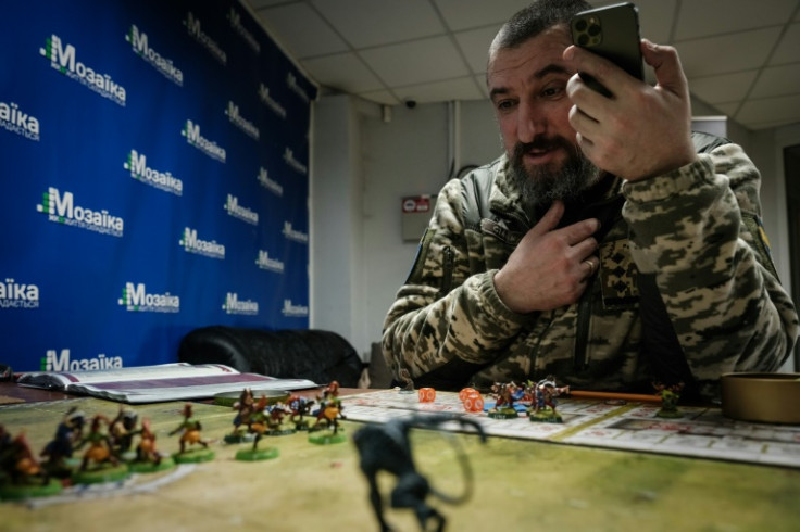 To kill time, Colonel Smak moves miniature figures around on a board, playing a British strategy game called "Blood Bowl" online with his 13-year-old son in the Netherlands