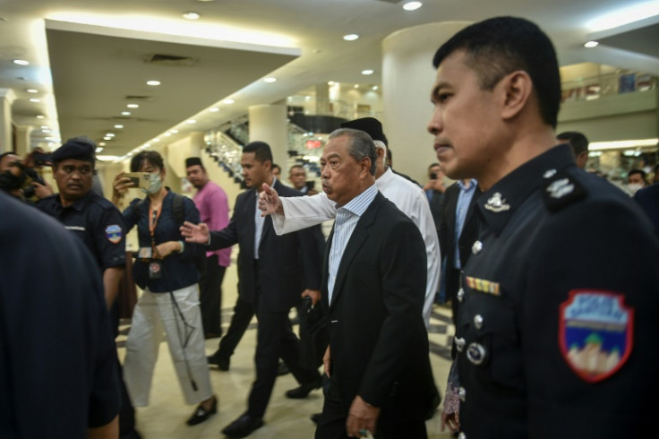 Malaysia's former prime minster Muhyiddin Yassin (C) has been charged with accepting bribes and money laundering
