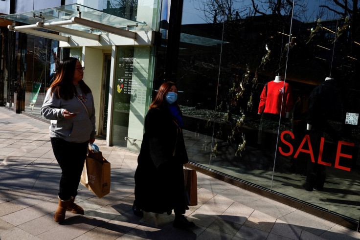Customers walk past a shopping area in Beijing