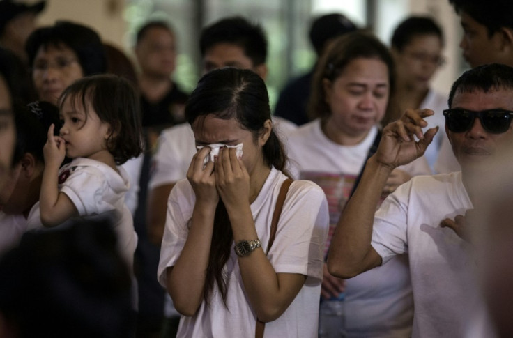 The sister of teenager Carl Arnaiz, who was killed by a Philippine police officer, cries at a mass ahead of his burial in 2017