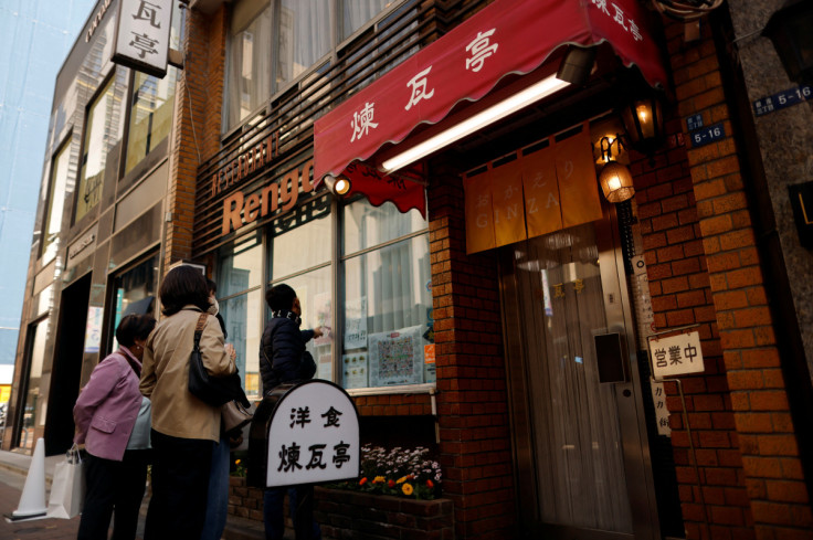 People check the menu list on a window of Rengatei restaurant in Tokyo