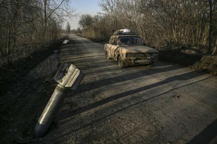A vehicle drives past a nailed missile tail in Chasiv Yar near Bakhmut