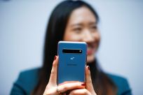 A Samsung employee poses with the new Samsung Galaxy S10 5G smartphone at a press event in London