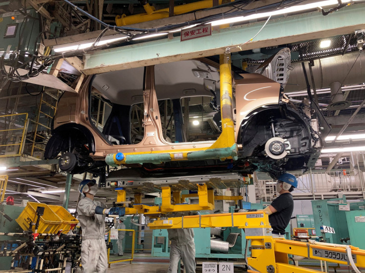 Workers install a battery for a new electric vehicle model at Mitsubishi Motor Corp's factory in Kurashiki