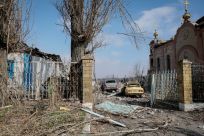 A view shows a residential building, cars and a church damaged by a Russian military strike in the frontline city of Avdiivka