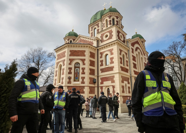 Ukrainian police officers stand next to St. George's Cathedral of the Ukrainian Orthodox Church, accused of being linked to Moscow in Lviv
