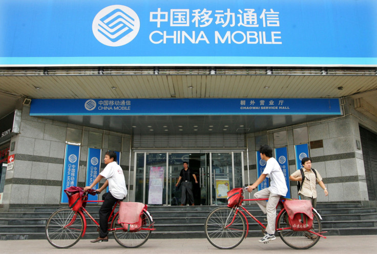 Chinese cyclists pedal past China Mobile office in Beijing.