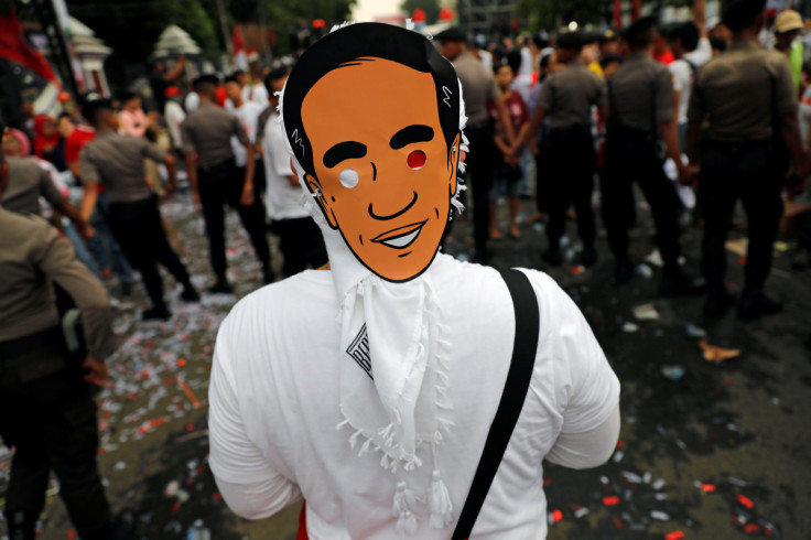A supporter wears a mask of Indonesia's presidential candidate Joko Widodo as he attends a carnival during a campaign rally in Tangerang