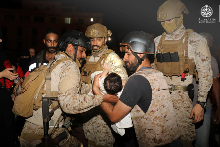 Saudi Royal Navy officers assist a child onboard their navy ship as they evacuate Saudis and other nationals are through Saudi Navy Ship from Sudan to escape the conflicts, Port Sudan