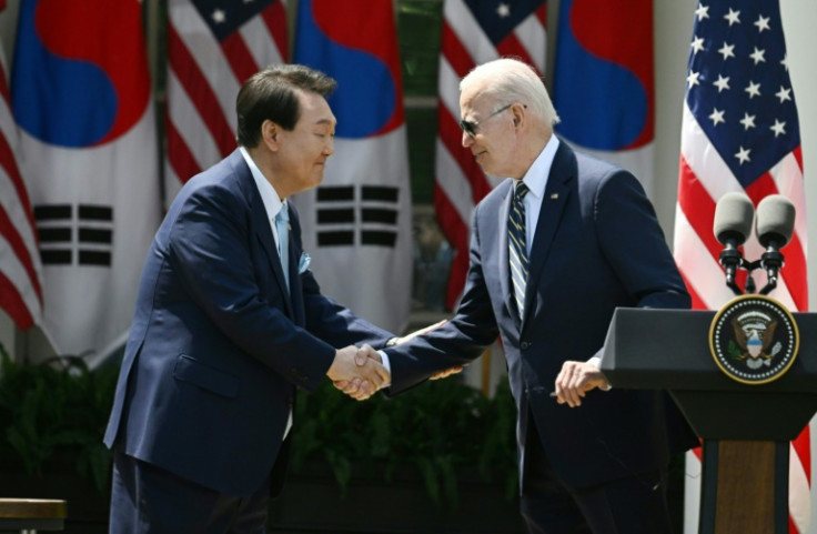 US President Joe Biden (R) shakes hands with Yoon Suk Yeol during the South Korean president's state visit