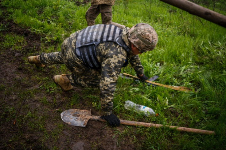 A Ukrainian serviceman drops to the ground to take cover during shelling near the frontline city of Bakhmut