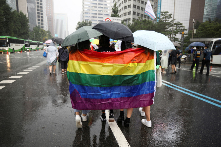 Participants wave a rainbow flag as they march on a street during the Korea Queer Culture Festival 2022 in central Seoul