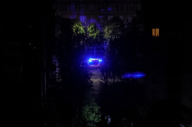An emergency services vehicle drives past a street during a Russian drone strike in Kyiv