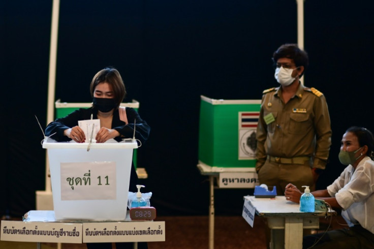 A woman casts her ballot during advance voting at a polling station in Bangkok ahead of the May 14 general election