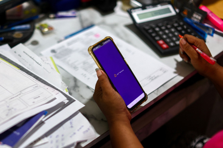 Kavita Wongyakasem, a small business owner, uses her mobile banking application to pay her bills at her house in Nonthaburi province on the outskirt of Bangkok