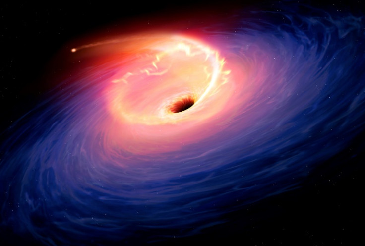 An artist's illustration of a star being sucked into a black hole -- just one theory for what caused the largest explosion astronomers have observed