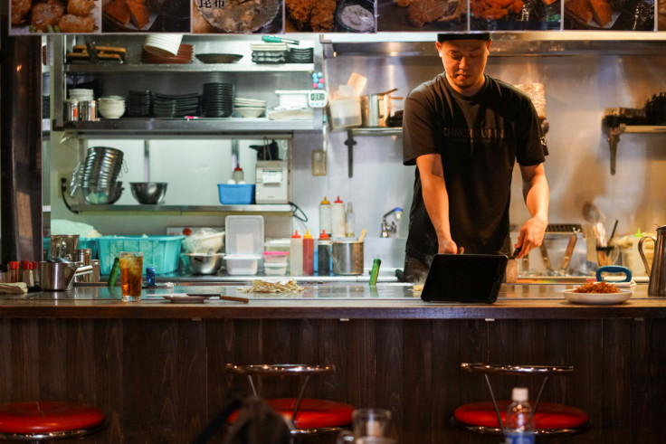 Atsuki Kitaura, manager at okonomiyaki specialty chain Chinchikurin, prepares okonomiyaki, in Hiroshima, Japan